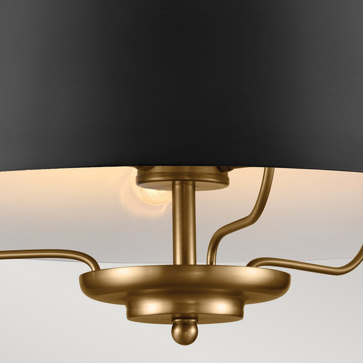 Close-up of the Luella 3 Light Duo-Mount Chandelier/Semi-Flush - Black & Brass, featuring a contemporary ceiling light with a matte black shade and brass accents. The gold central post and arms support three bulbs that project soft illumination upwards, providing a warm, ambient glow in any duo-mount setting.