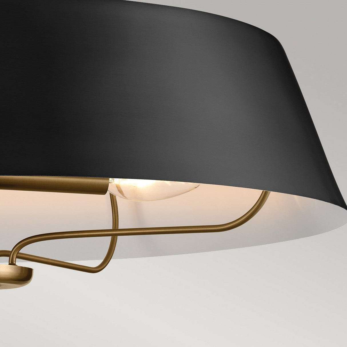 Close-up of the Luella 4 Light Duo-Mount Chandelier/Semi-Flush in Black & Brass, a modern ceiling light fixture. The design showcases a sleek, angled shade with an exposed bulb, emphasizing its contemporary and minimalistic style. Its versatile duo mount option allows it to enhance any space effortlessly.