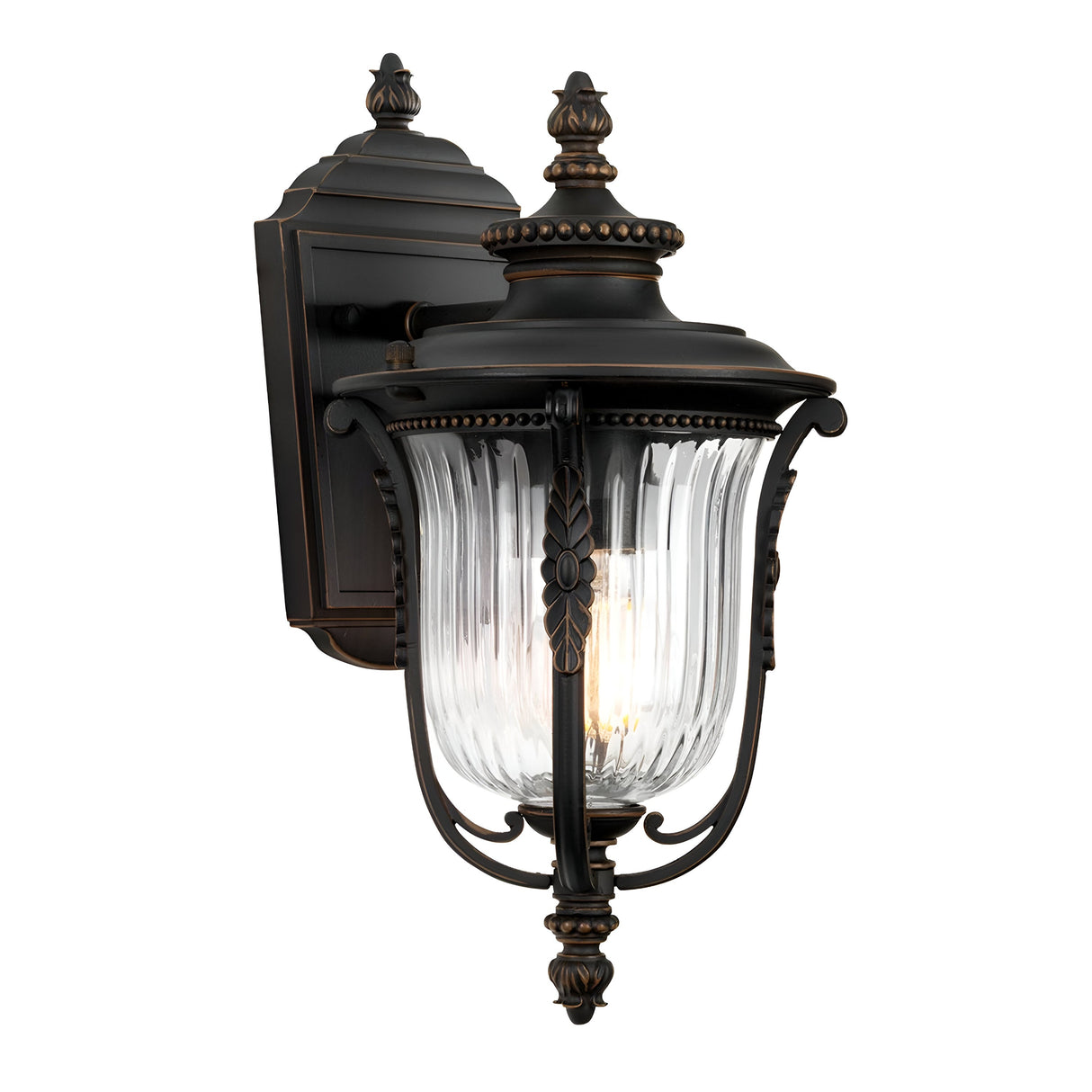 The Luverne Outdoor 1 Light Small Wall Lantern in rubbed bronze showcases a ribbed glass shade with intricate decorative detailing.