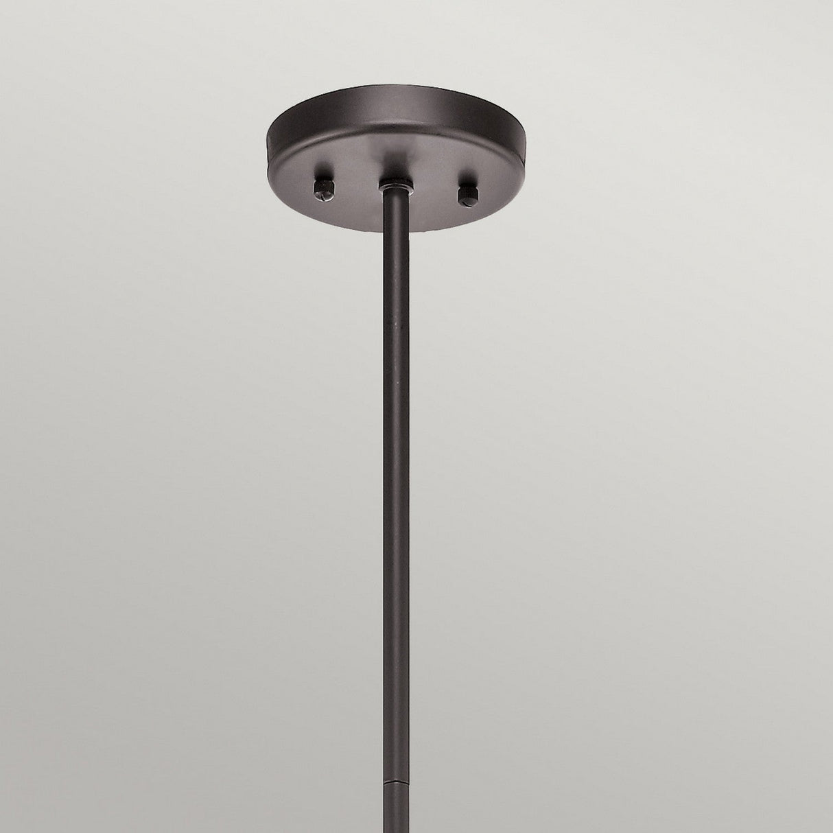 A close-up of the Lyndon Outdoor 5 Light Outdoor Chandelier, featuring a black finish with architectural bronze detailing and a straight metal rod extending downwards, set against a plain gray background.