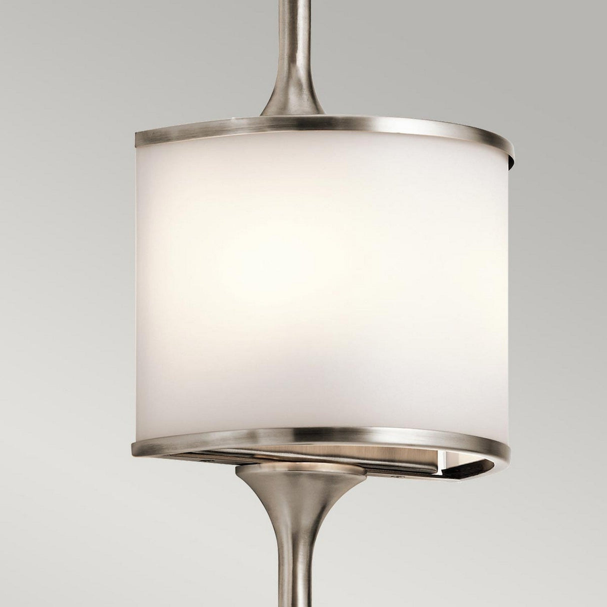 The Mona 2 Light Large Wall Light - Silver showcases a modern pendant light design with mid-century-inspired elements, featuring a cylindrical white frosted shade and sleek metallic frame. Its elegant silver finish stands out beautifully against a light gray background.
