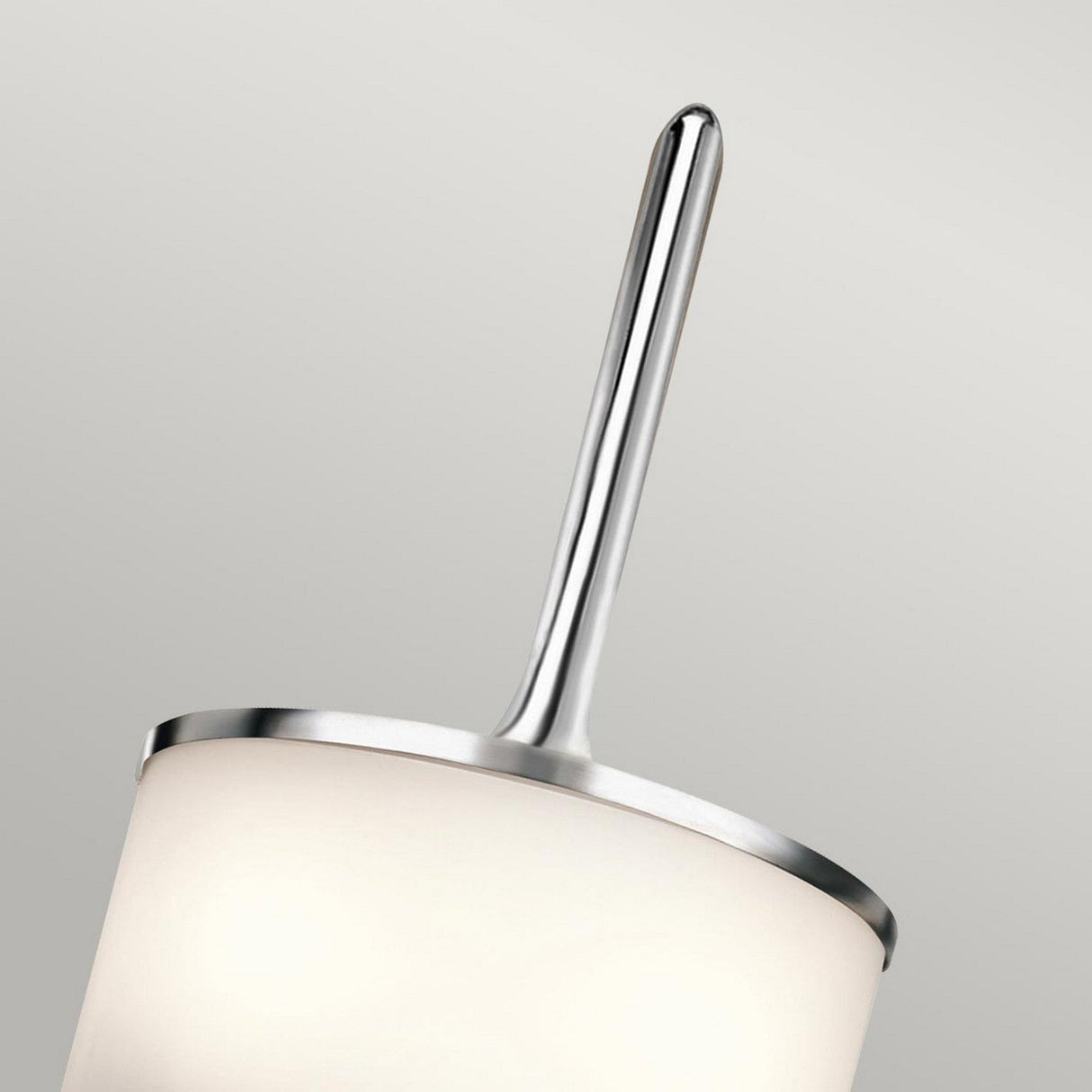 Close-up of the Mona 2 Light Small Wall Light in polished chrome, featuring a cylindrical white shade with sleek metallic accents. The minimalist design complements G9 LED lamps, offering a stylish and refined aesthetic against a neutral background.