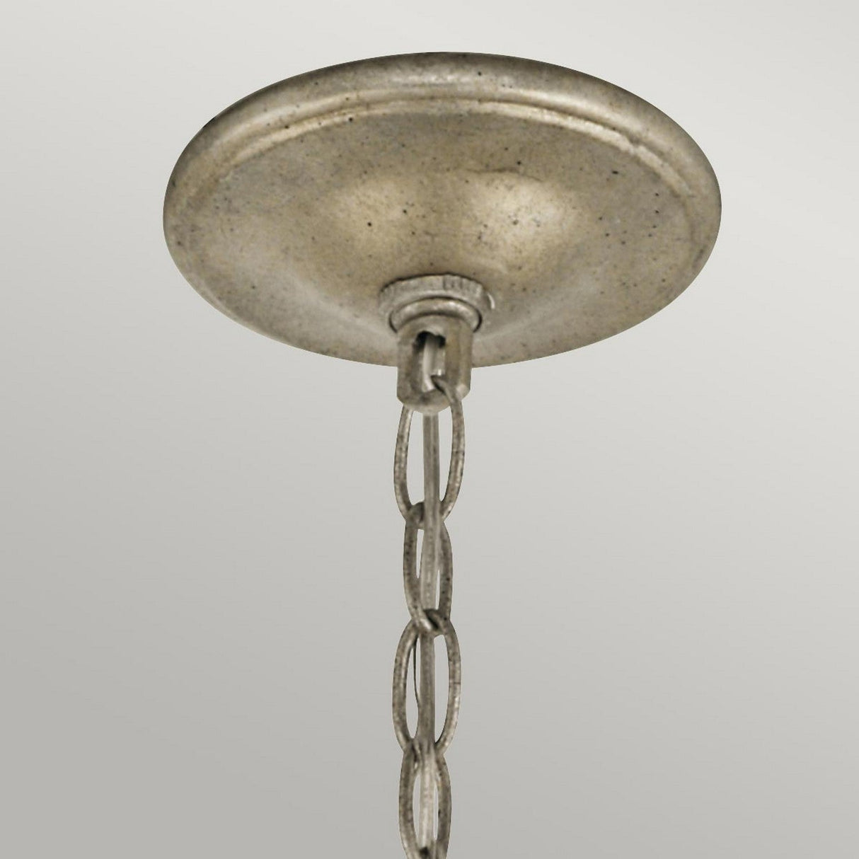 The Rosalie 5 Light Mini Chandelier in Sterling Gold is shown in a close-up view, featuring its elegant ceiling-mounted fixture with a sterling gold metallic canopy. A delicate chain cascades from its center, set against a softly lit gray background.