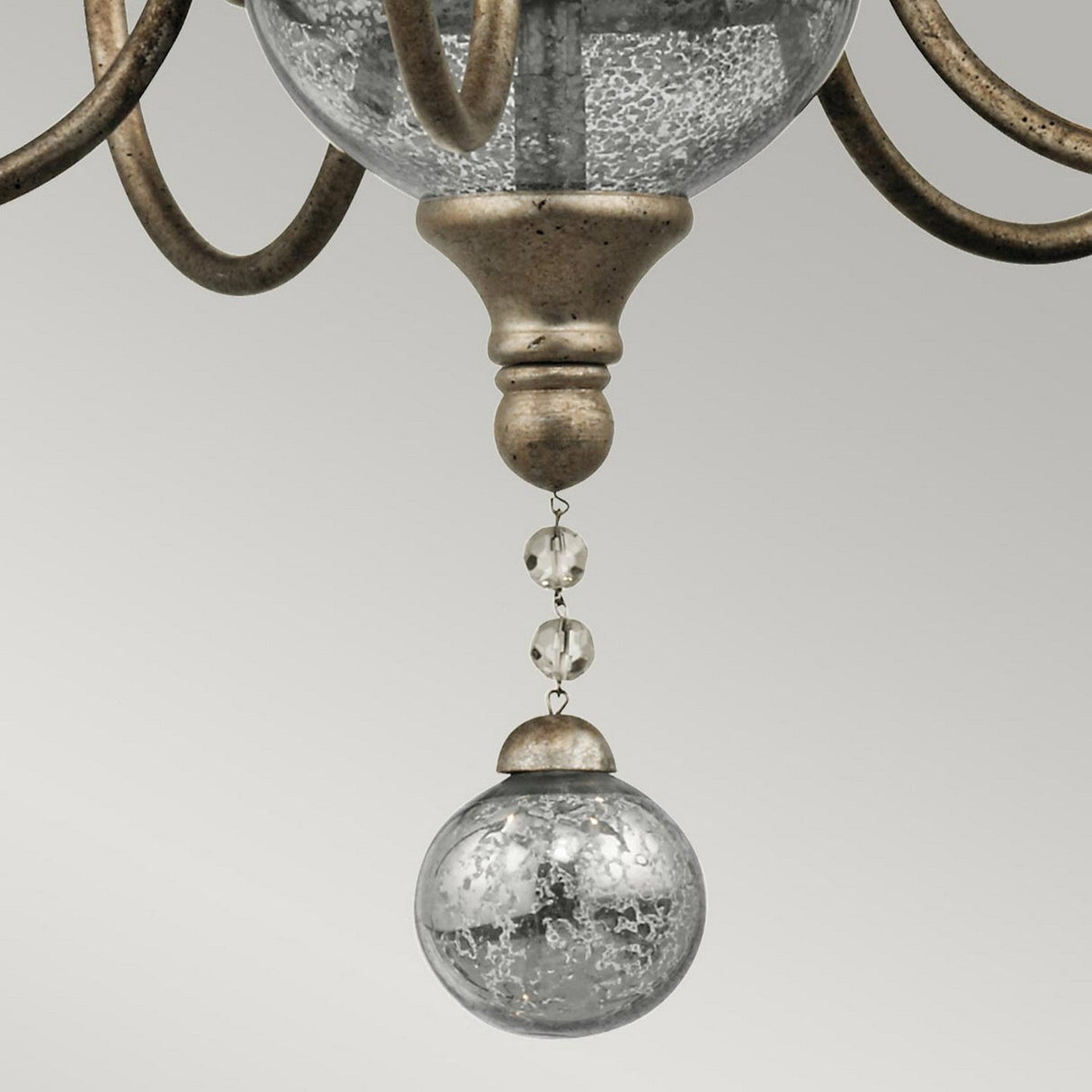 Close-up of the Rosalie 5 Light Mini Chandelier in Sterling Gold, featuring a metallic antique bronze finish. It showcases an Antique Mercury Glass orb with a cracked finish, suspended by small crystal beads from a decorative fixture against a gray background. Curved metal arms extend elegantly from the fixture.
