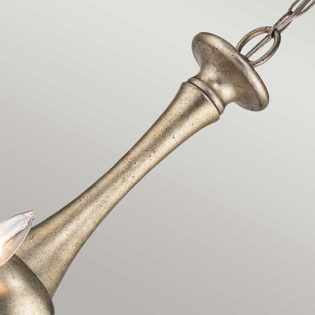 Close-up of the Rosalie 5 Light Chandelier in Sterling Gold, showcasing Williamsburg design elements with a smooth, elongated look and a dark chain. Its textured surface and slightly flared top reveal hints of Antique Mercury Glass detail on the side.