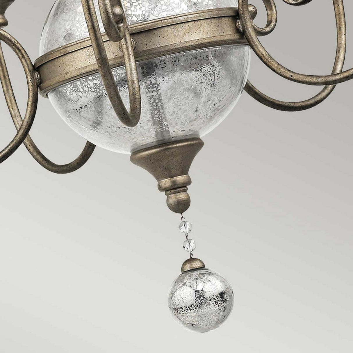 Close-up of a decorative detail from the Rosalie 5 Light Chandelier in Sterling Gold, showcasing a crackled glass globe with metal accents that mimic the appearance of Antique Mercury Glass, linked to a smaller hanging glass orb, all set against a neutral backdrop.