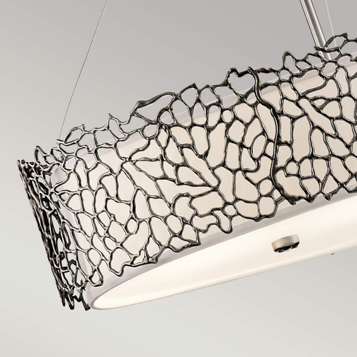 Introducing the Silver Coral 4 Light Oval Island Suspension in silver, this contemporary pendant light boasts a white cylindrical shade beautifully encased within an abstract open frame featuring a distinctive silver coral design. The elegant island light is suspended gracefully from a slender rod, making it a striking addition to any neutral setting.