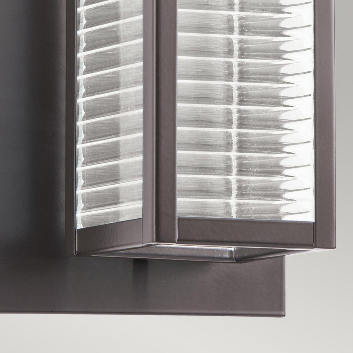 Close-up of the Sorel Outdoor 1 Light Wall Lantern in Bronze, showcasing a geometric, rectangular design. The light includes a textured, translucent cover set within an Architectural Bronze frame and is mounted on a flat base, embodying a contemporary and minimalist style.