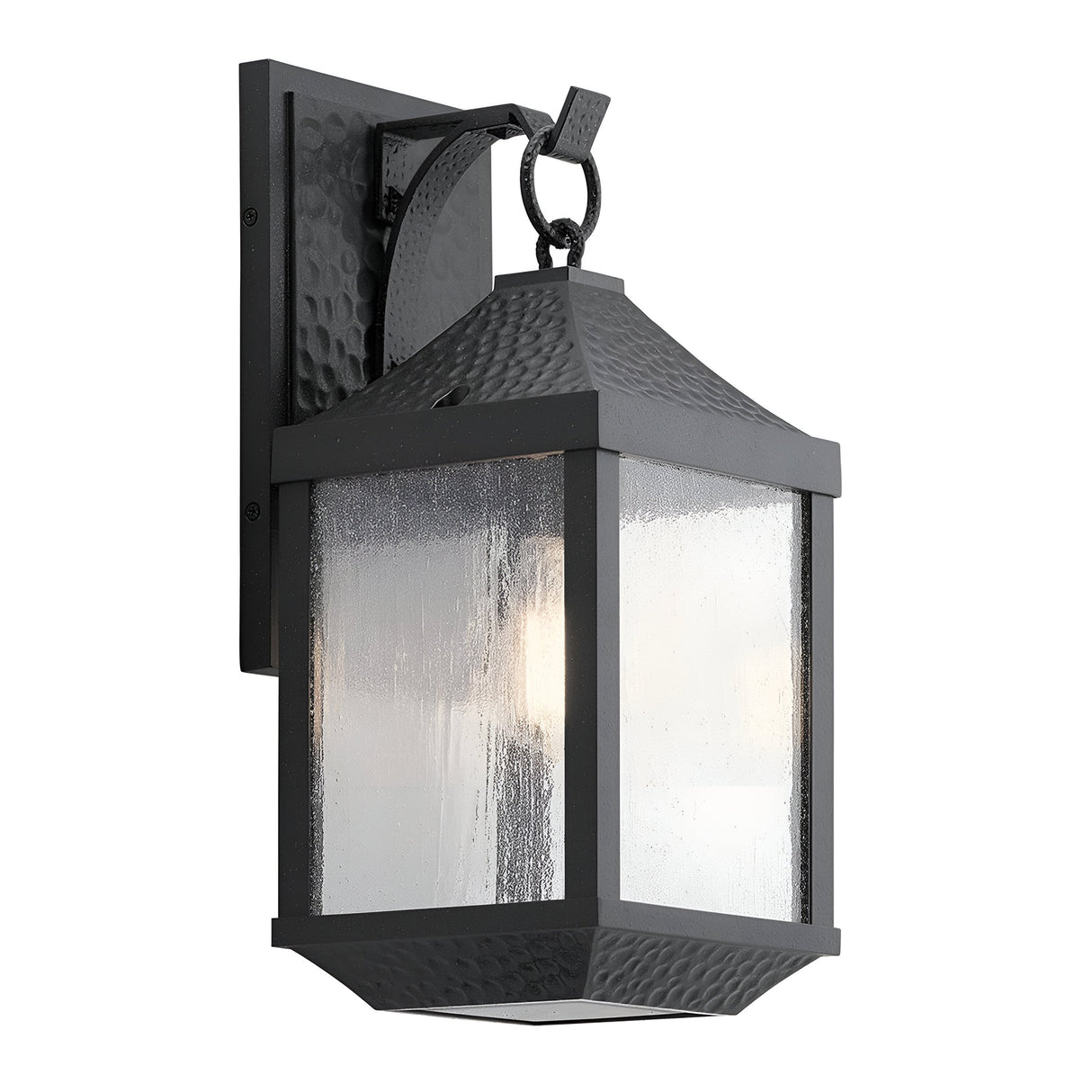 The Springfield Outdoor 1 Light Medium Wall Lantern - Black is designed with a distressed black finish and clear, seeded glass panels. It features an elegant design with a rectangular backplate and a looped decorative handle at the top.