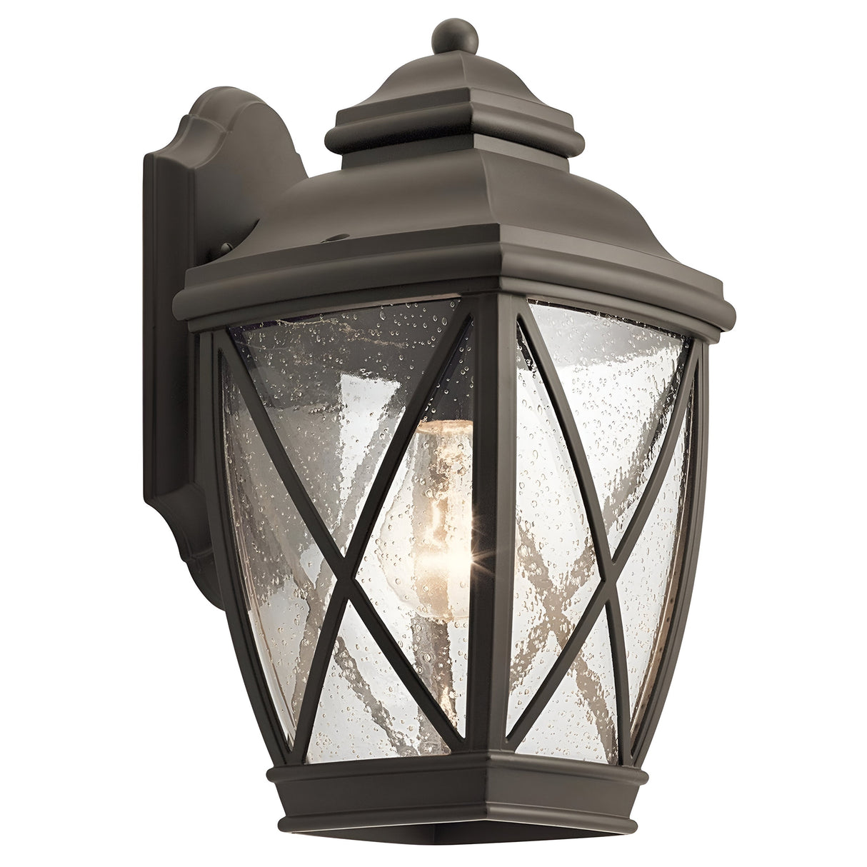 The Tangier Outdoor 1 Light Medium Wall Lantern in Olde Bronze boasts an IP44 rating and clear seeded glass panels. Its ornate cap and decorative crossbar frame enhance its classic and elegant design, making it perfect for wall mounting.