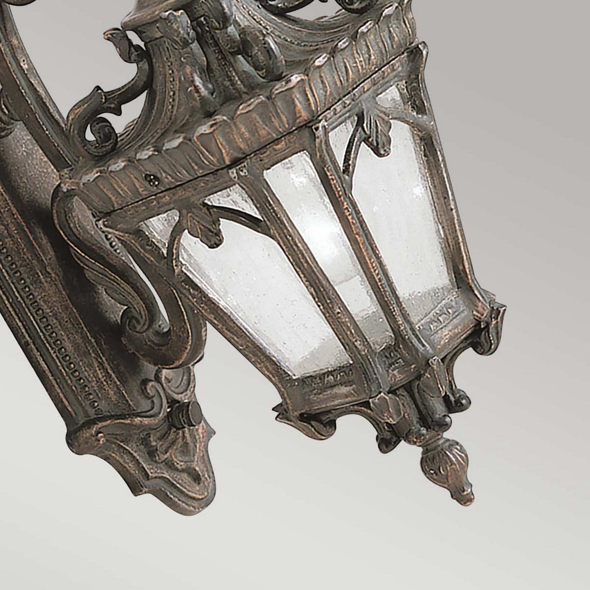 The Tournai Outdoor 1 Light Medium Wall Lantern in bronze boasts a vintage-style with ornate details and seedy glass panels, making it an ideal choice for elevating your outdoor decor.