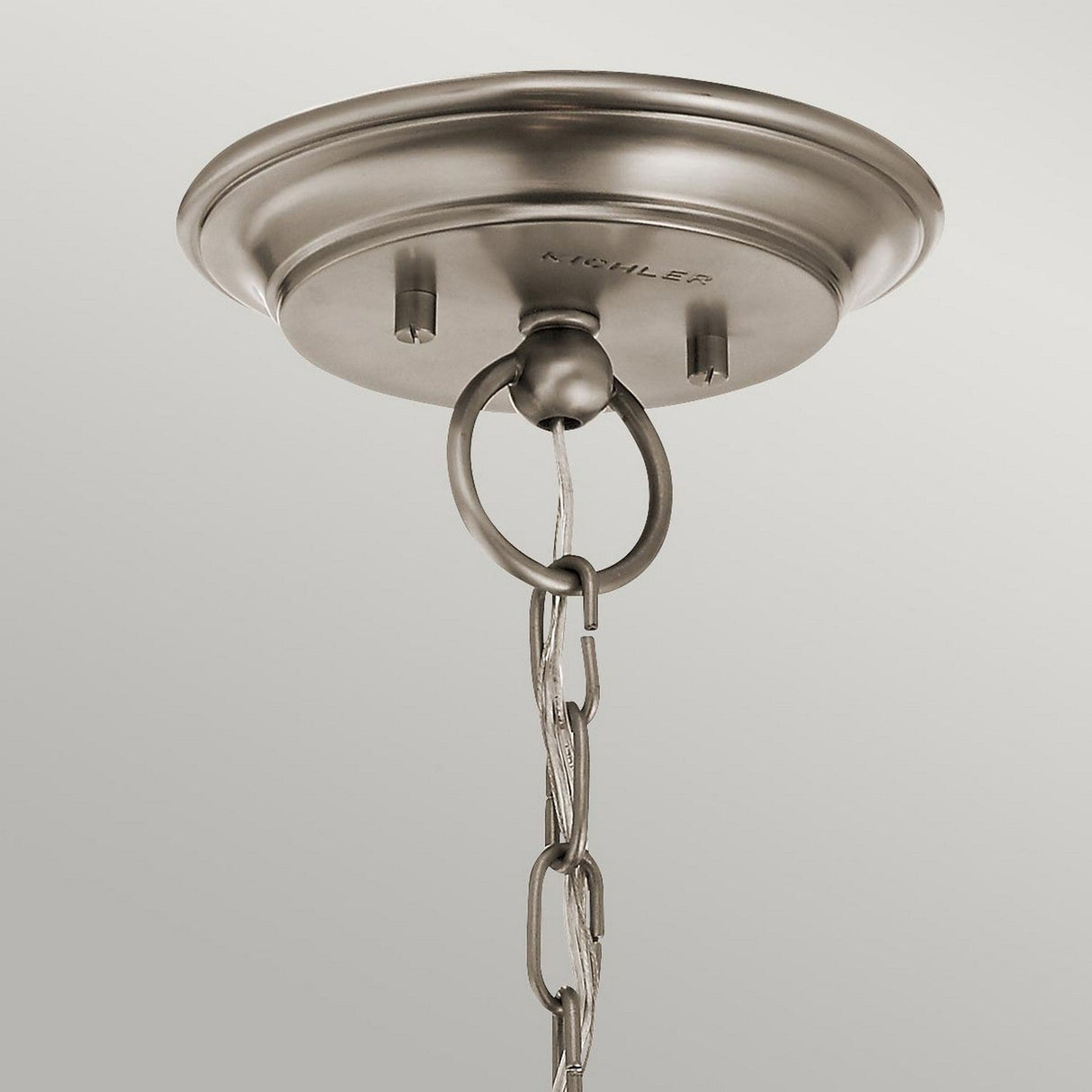 The Waverly 3 Light Chandelier - Silver features a sleek, circular design with a brushed metal ceiling canopy. Its chain and electrical cord elegantly hang from a central hook, adding an elegant touch to this piece of vintage lighting.