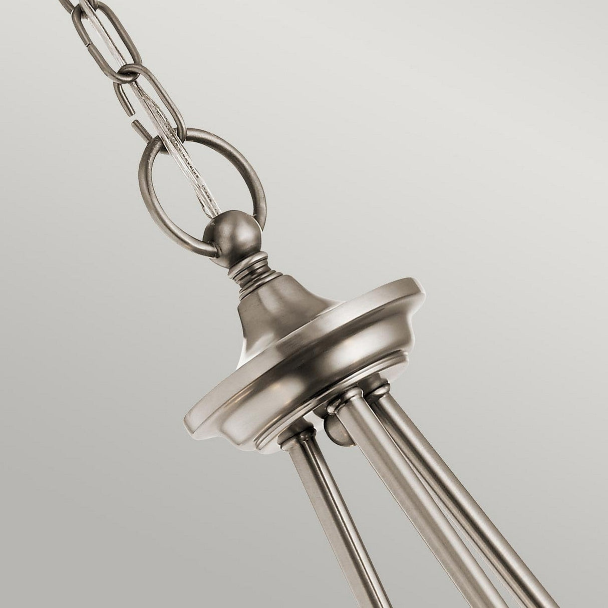 Close-up of a metallic chain from the Waverly 3 Light Chandelier - Silver, showcasing a circular hook and a sleek, brushed metal finish. The background in neutral gray highlights its elegant and modern aesthetic reminiscent of vintage lighting.