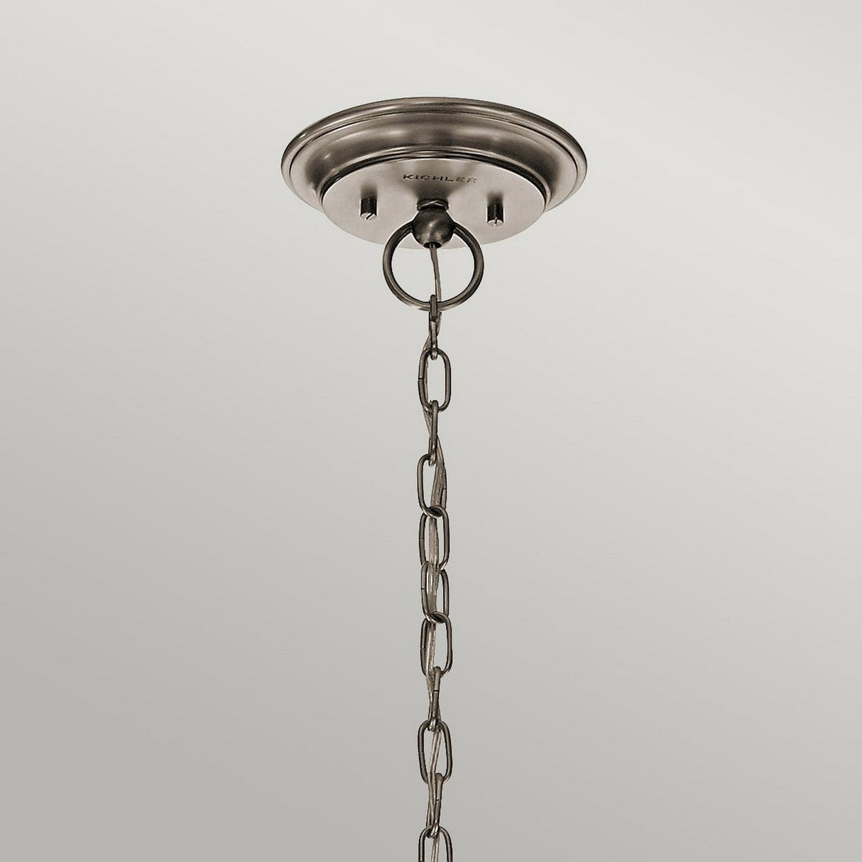 The Waverly 5 Light Chandelier - Silver elegantly hangs with its metal ceiling fixture, showcasing a round base and attached chain. The chain weaves through a circular mount, highlighted by seeded glass shades and a lustrous silver finish, all against a simple light gray backdrop.