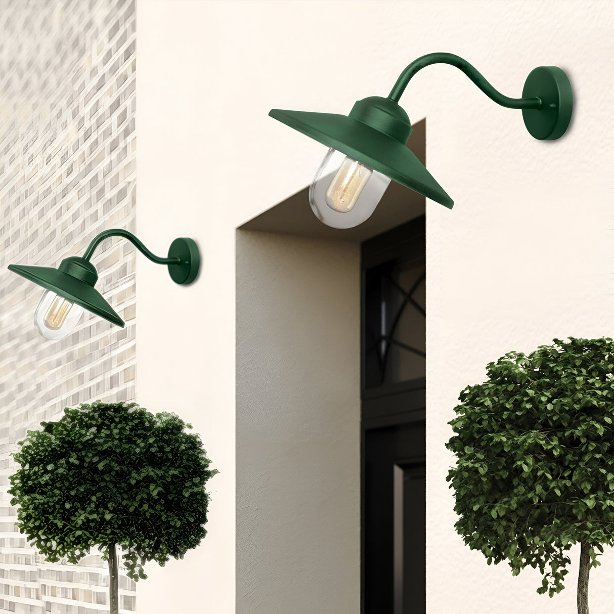 Two Klampenborg 1 Light Outdoor Wall Lights in green, equipped with vintage-style bulbs and an IP44 rating, are mounted on a white brick wall beside a window. Below them, two neatly trimmed round bushes add a touch of greenery to the Scandinavian design scene.