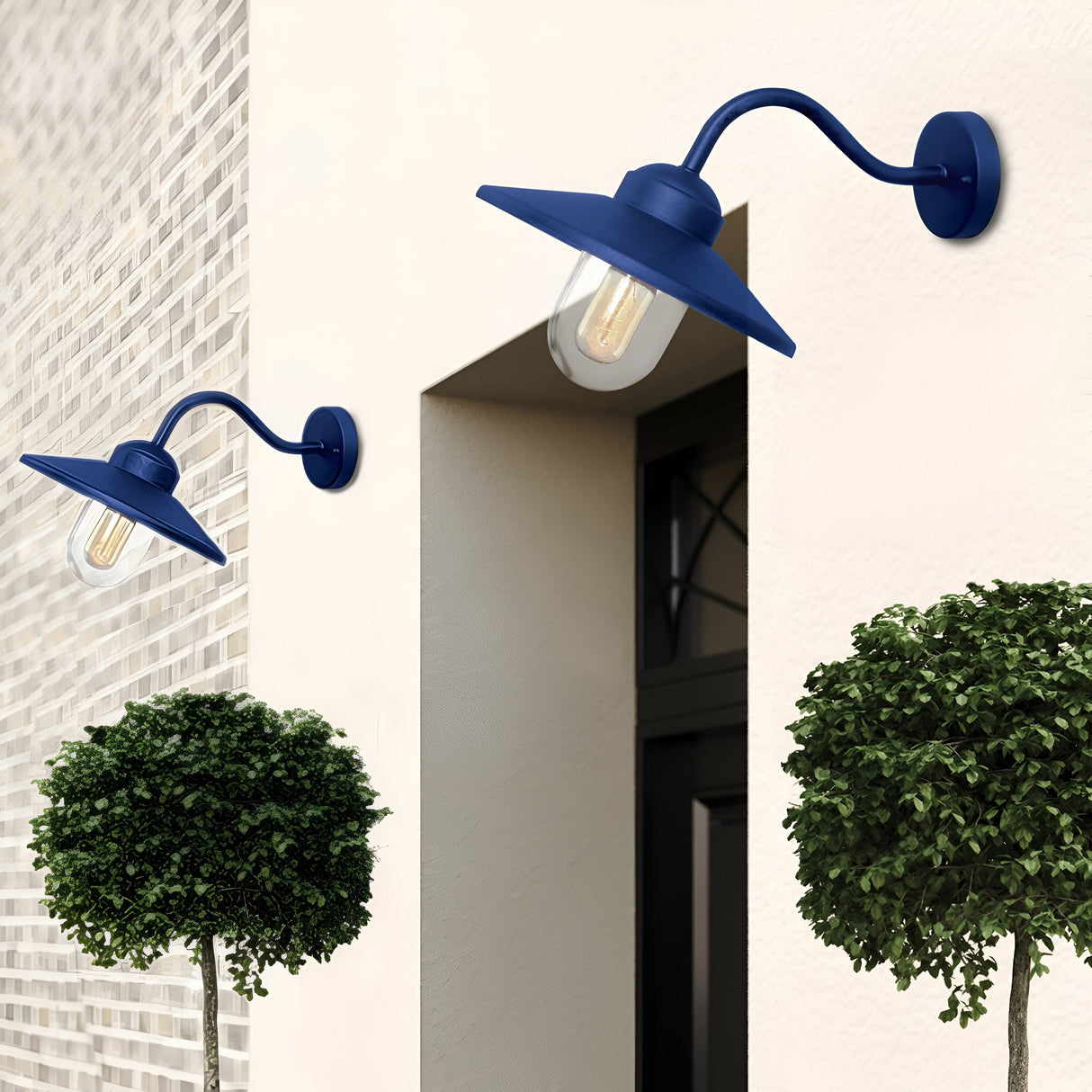 Two Klampenborg 1 Light Outdoor Wall Lights in navy blue, featuring a Scandinavian-inspired design and IP44 rating, are mounted on a light brick wall beside a window. Below them, two neatly trimmed round bushes enhance the modern aesthetic.