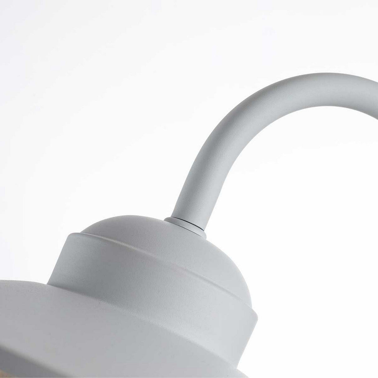 Close-up of the upper part of the Klampenborg 1 Light Outdoor Wall Light in matte white, featuring a curved arm against a white background. The minimalist design embodies a contemporary style, reminiscent of Scandinavian outdoor wall lights with its durable stainless steel construction.