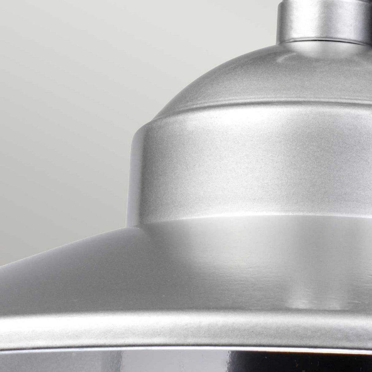 Close-up view of the Klampenborg 1 Light Outdoor Chain Pendant in metallic silver, focusing on the smooth top portion and edge. The plain light gray background accentuates its sleek, shiny texture that echoes Scandinavian minimalism.