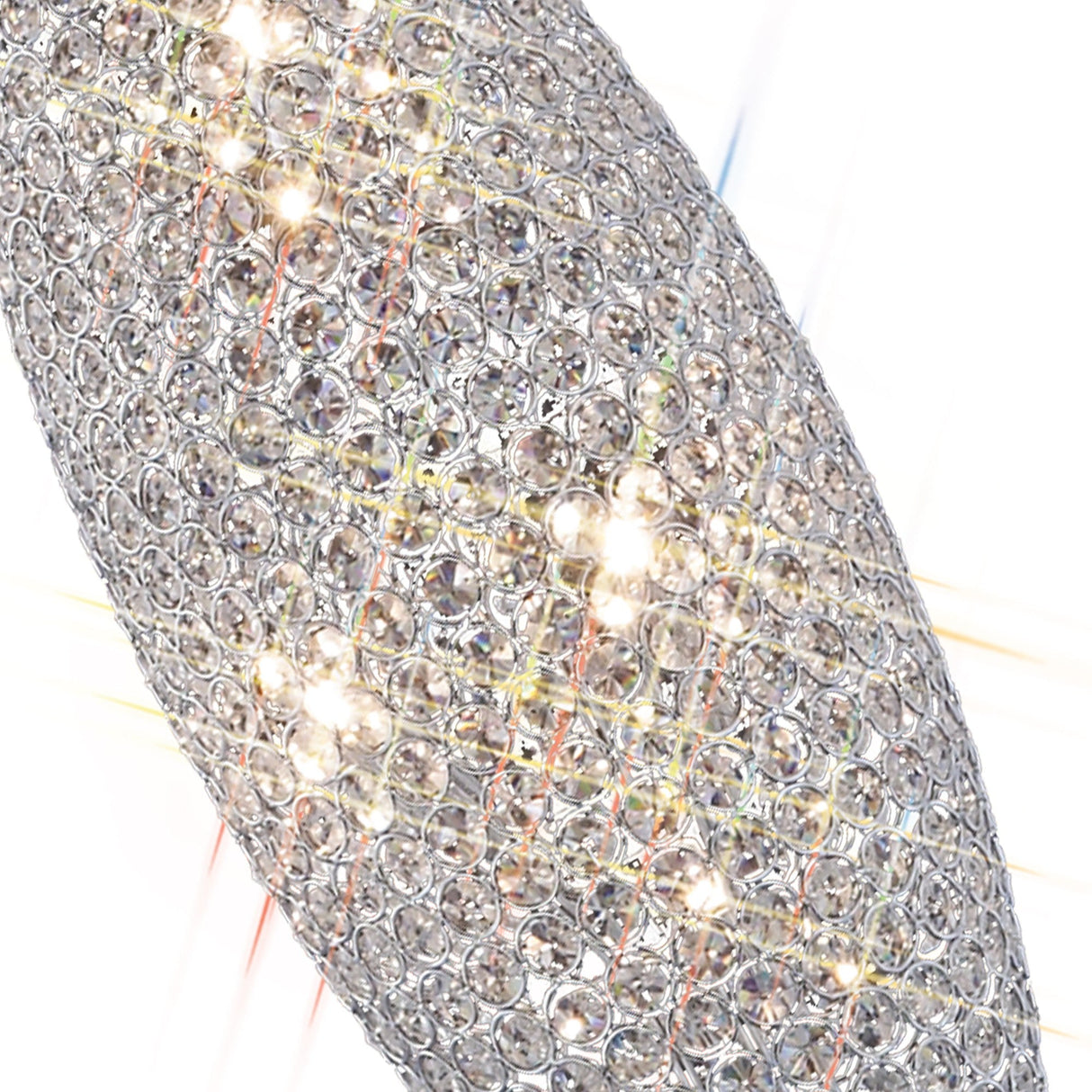 Close-up of the Kos 4 Light Crystal Floor Lamp in polished chrome, featuring a silver oval design encrusted with sparkling crystals that reflect and refract light against a bright, blurred background.