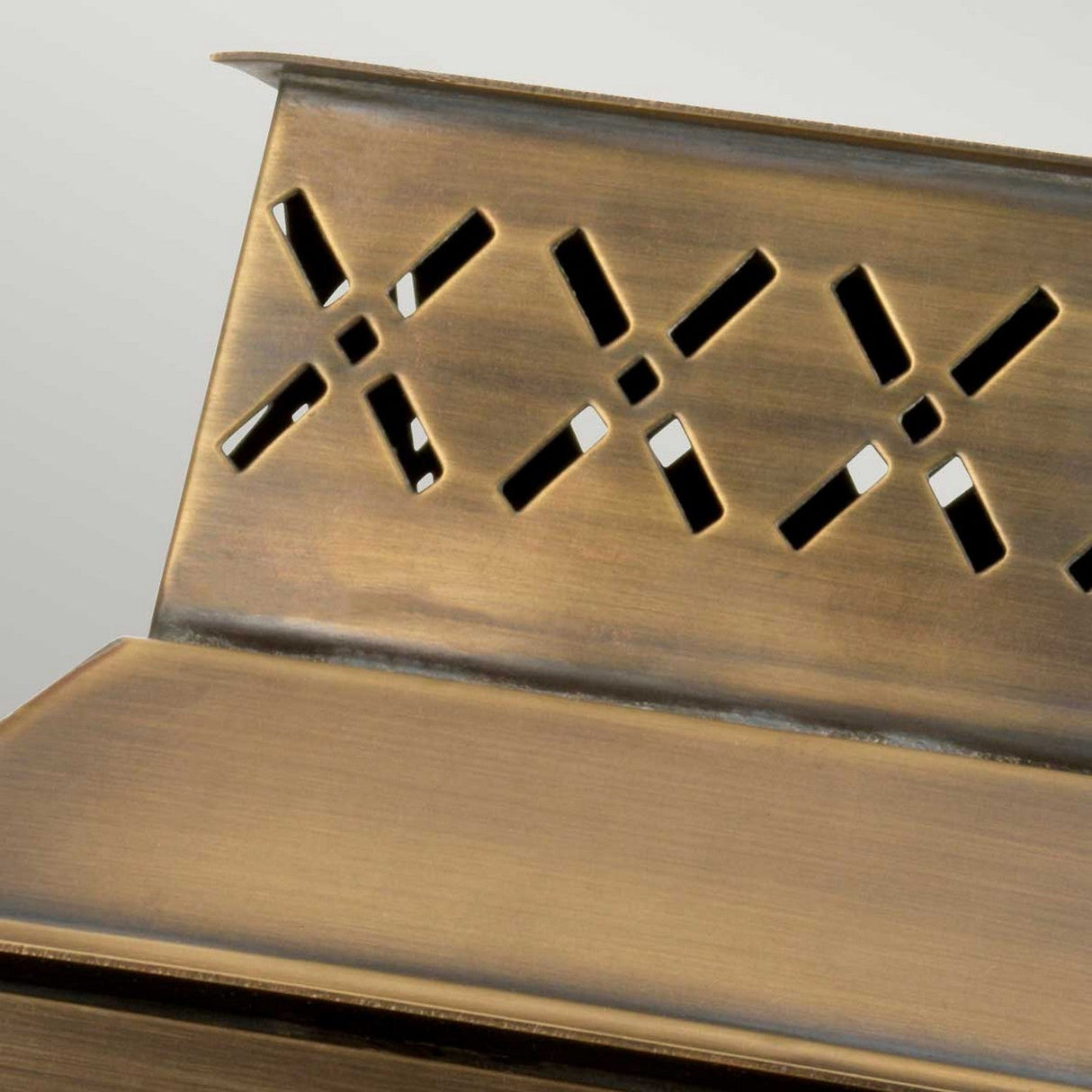 Close-up of the Lambeth Palace 1 Light Outdoor Wall Light in aged brass, showcasing its decorative metal surface with an intricate cutout pattern. The design features a slightly weathered look that highlights the contrast between its polished and dull areas, much like an aged brass finish.