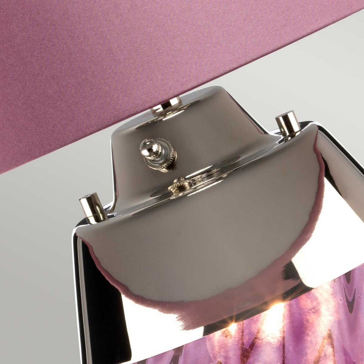 Close-up of the Lena 2 Light Small Plum Table Lamp - Heather Shade, showcasing a metallic base with a glossy finish that reflects light. The lamp features a textured heather satin shade and a reflective surface with shades of purple and silver, adding an elegant and modern touch.