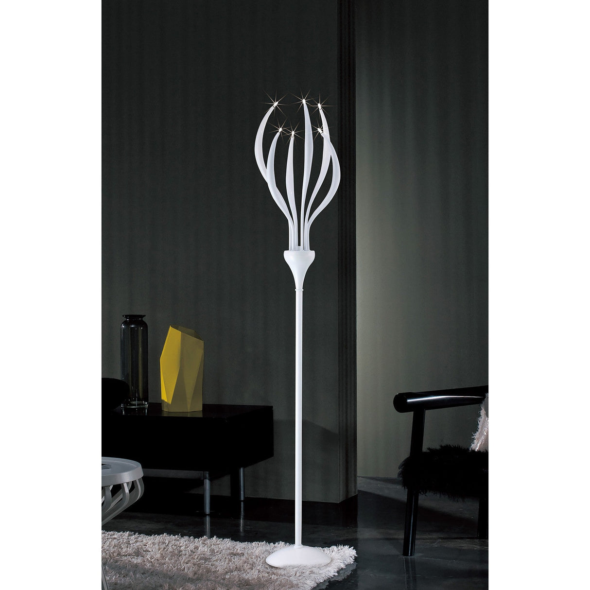 The Llamas 6 Light Floor Lamp in gloss white features multiple curved arms with small lights, standing in a dim room with dark walls, a shaggy rug, black chair, and geometric decor on the side table.