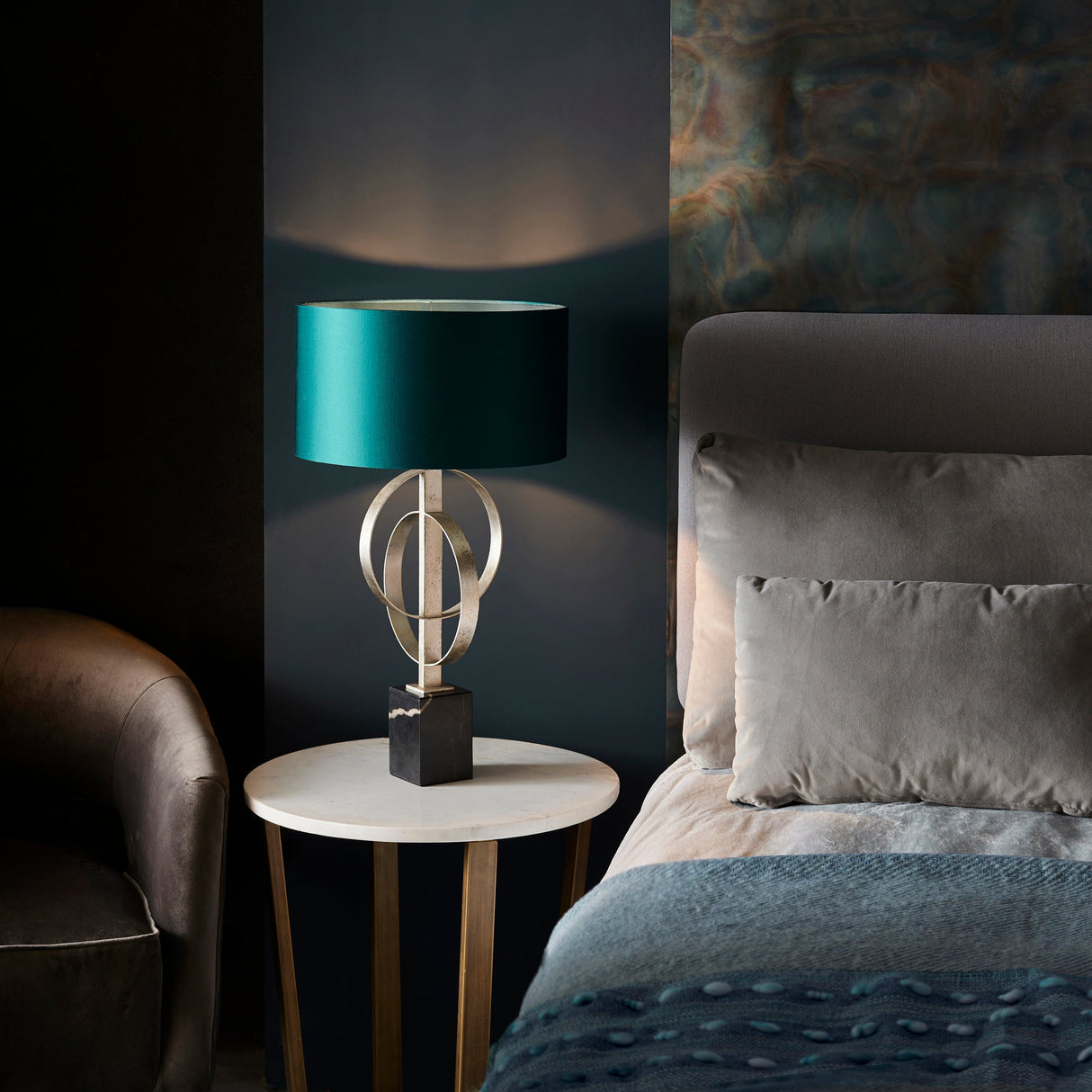 Sparrowmere Double Hoop table lamp from Lighting No.1 with silver leaf metal hoops, teal drum shade and marble base on a bedside table.