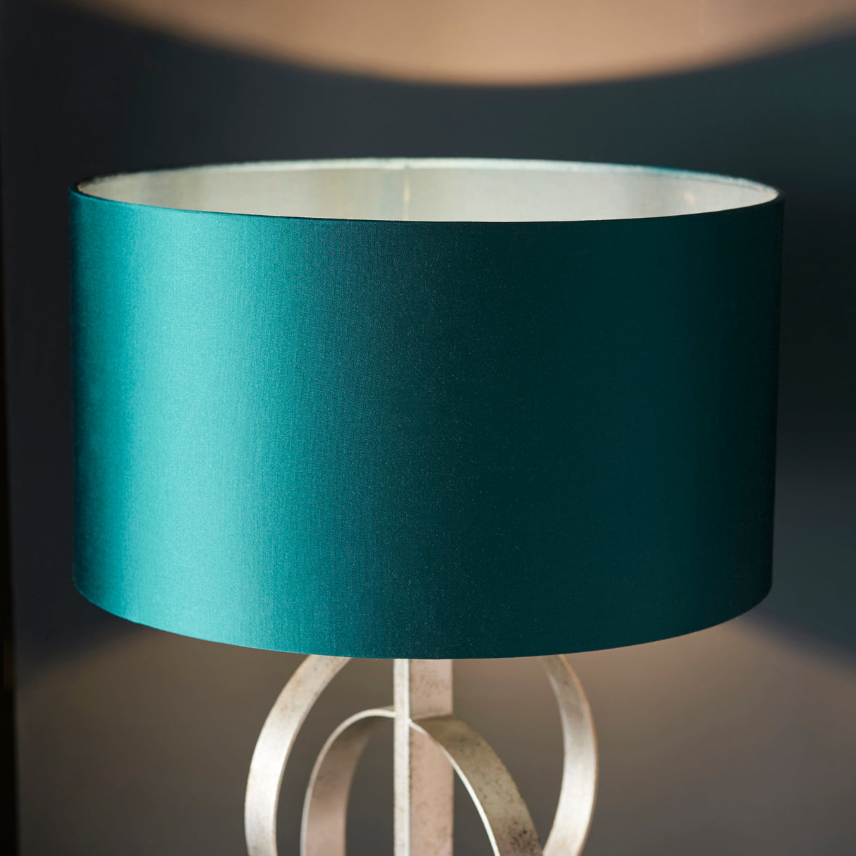 Close-up of the Sparrowmere Double Hoop table lamp by Lighting No.1, showing the deep teal fabric drum shade above the silver leaf metal hoops.