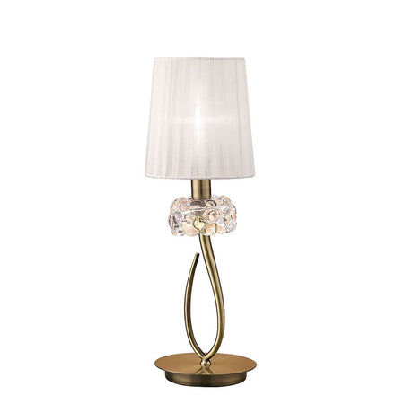 The Loewe Small 1 Light Table Lamp features an antique brass round base, a curved metallic stem, a crystal accent, and a white pleated fabric shade for a modern touch.