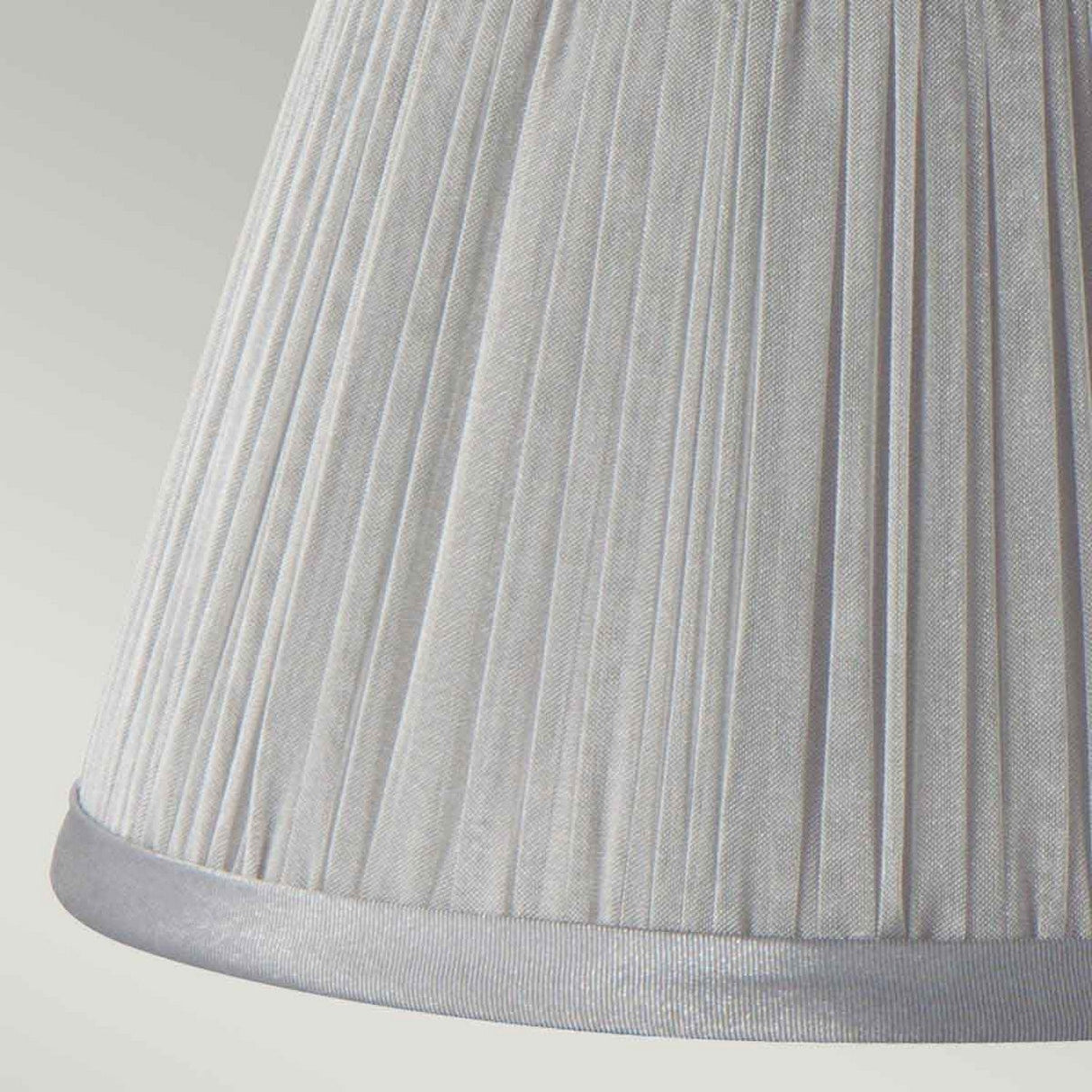Close-up of the Clip Shades Pleated Grey Chiffon Candle Shade, featuring a white pleated chiffon design with smooth silver-gray trim at the base, set against a light background. The slightly conical shade highlights its vertical pleat details, making it an ideal chic clip-on candle shade.