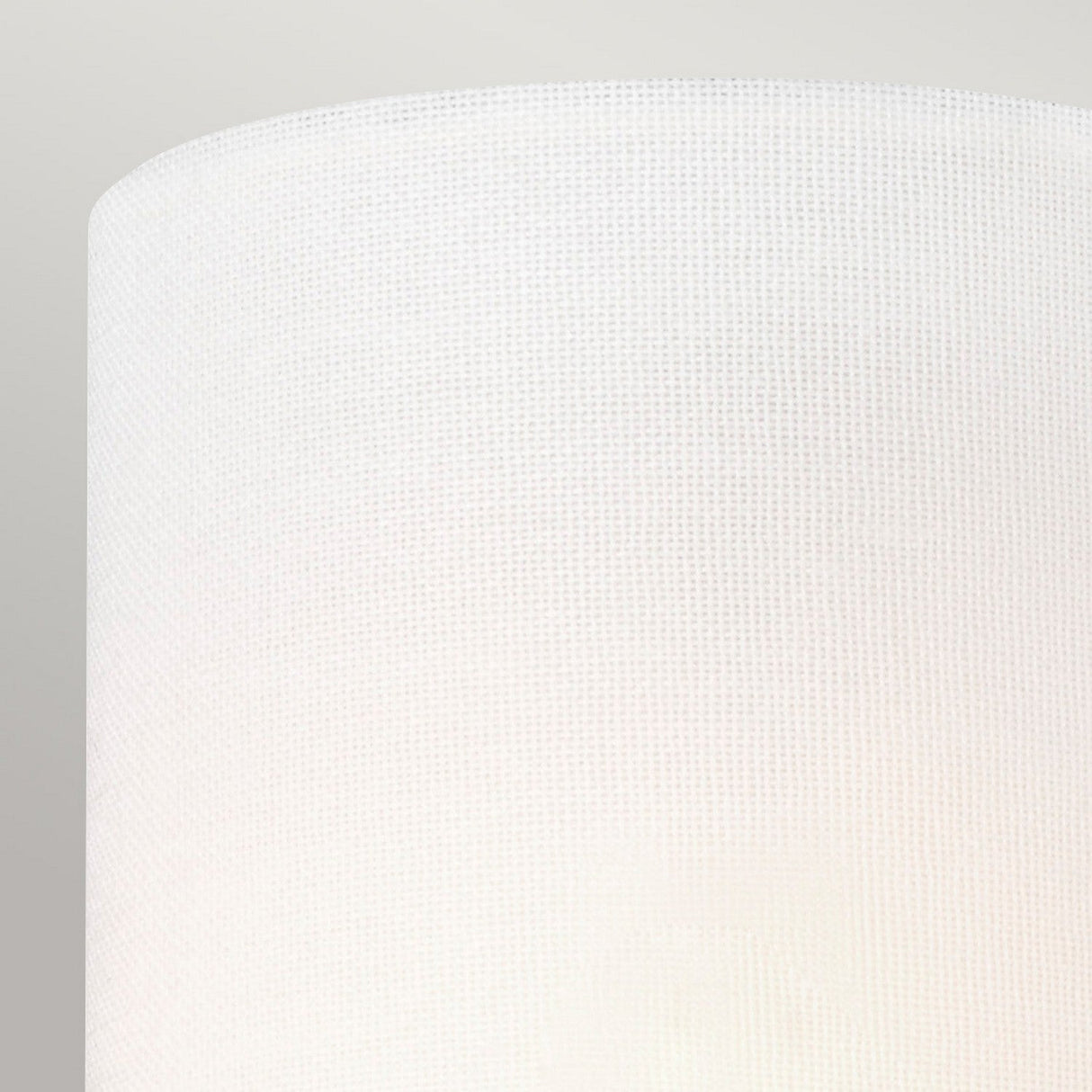 Close-up of the Clip Shades - Ivory Linen, featuring a textured fabric surface that beautifully complements ambient lighting. The candle bulb fixture enhances the serene glow against a plain, neutral background.