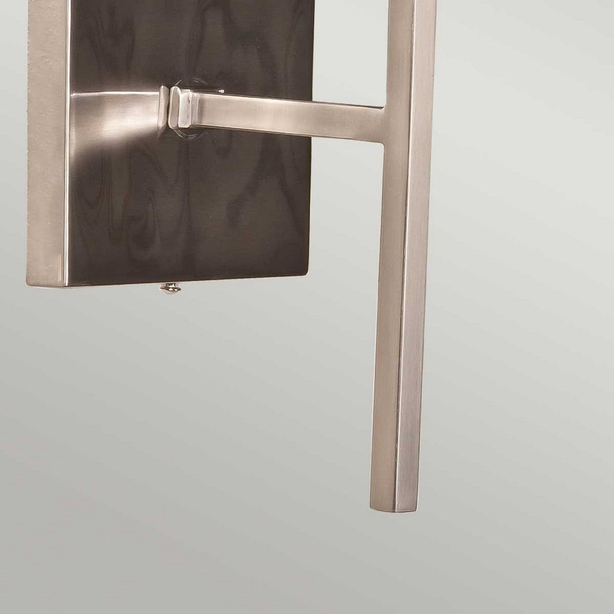 Close-up of the Lucerne 1 Light Wall Light, featuring a sleek brushed nickel finish and a grey shade. Its clean lines and square base enhance the contemporary ambiance against a light gray background.