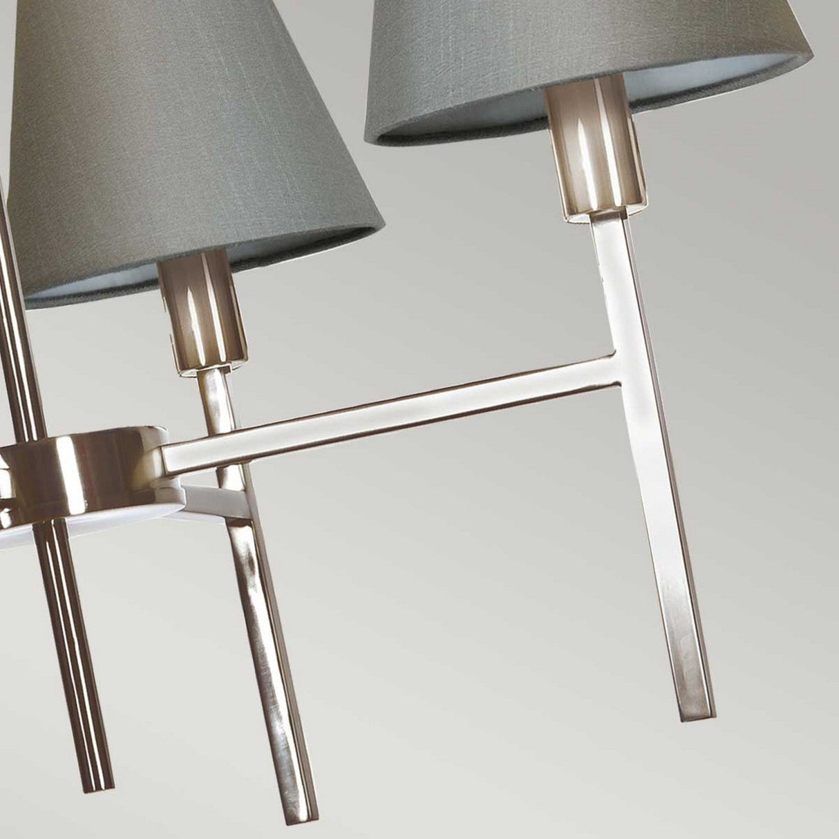 Close-up of the Lucerne 4 Light Chandelier - Brushed Nickel With Grey Shade, showcasing sleek metallic arms in brushed nickel and cylindrical, gray fabric shades. This design embodies modern luxury with its minimalist elegance and emphasis on contrasting textures of metal and fabric.