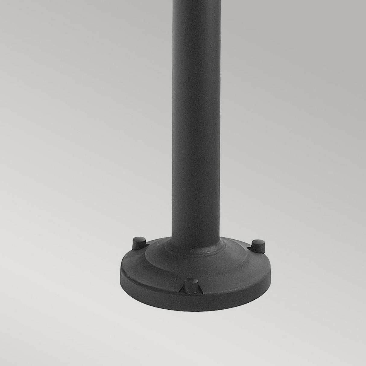 A close-up view of the Lund 1 Light Lamp Post - Black, showcasing its black telescopic cylindrical design with a round base and three protruding bolts. Made from galvanized steel, it is set against a plain, light gray background.