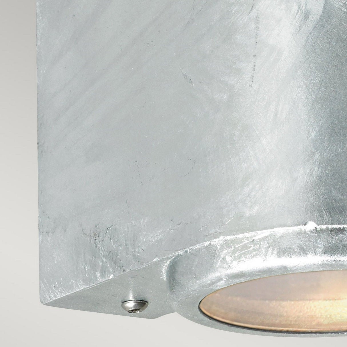 Introducing the Mandal Outdoor LED Up/Down Wall Light in sleek silver, crafted from robust galvanized steel. This contemporary cylindrical fixture provides energy-efficient lighting with a gentle, warm glow from its circular underside opening, enhancing its textured surface with a welcoming ambiance.