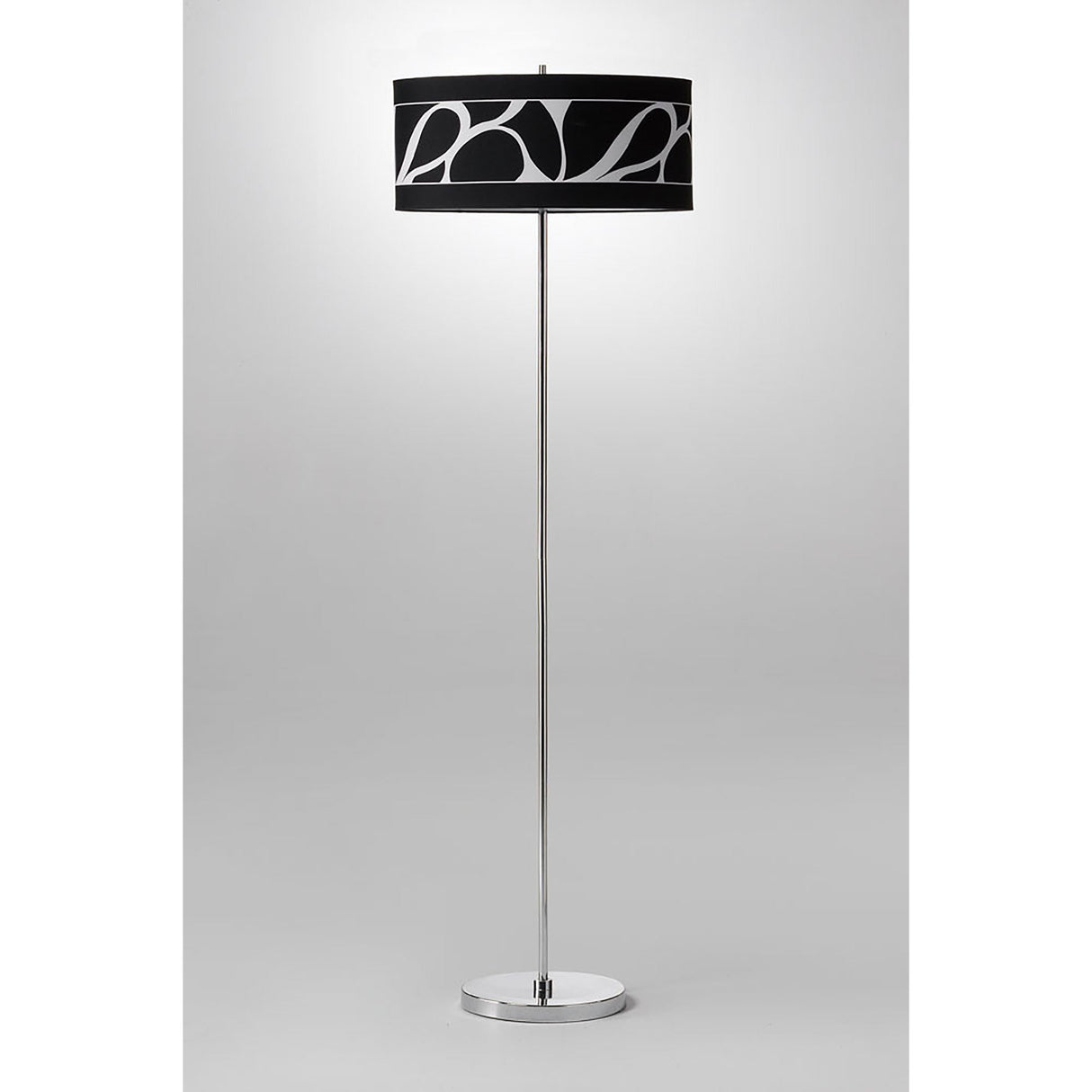 The Manhattan 3 Light Floor Lamp features a slim chrome stand and a round black shade with a bold abstract pattern, set against a plain light gray background.