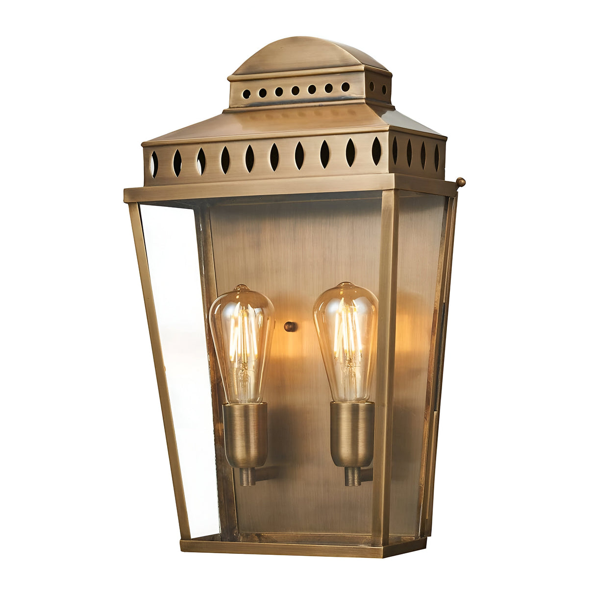 Introducing the Mansion 2 Light Outdoor Wall Light in Aged Brass: a vintage-style outdoor fixture with two exposed bulbs, a rectangular body, and a sloped top. Made from solid brass, this lantern features a glass enclosure with decorative cutouts along the top edge, ideal for IP44-rated outdoor lighting.
