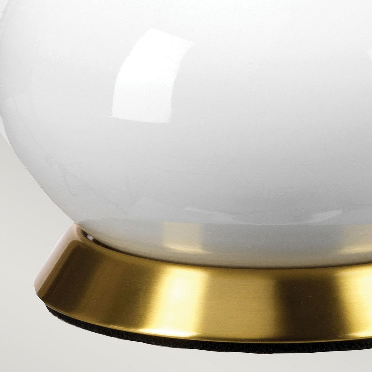 Close-up of the Milo 1 Light Table Lamp, featuring a glossy light blue spherical design mounted on an aged brass base. The surface reflects light, enhancing its polished appearance and highlighting the contrast between the smooth light blue and metallic gold tones.
