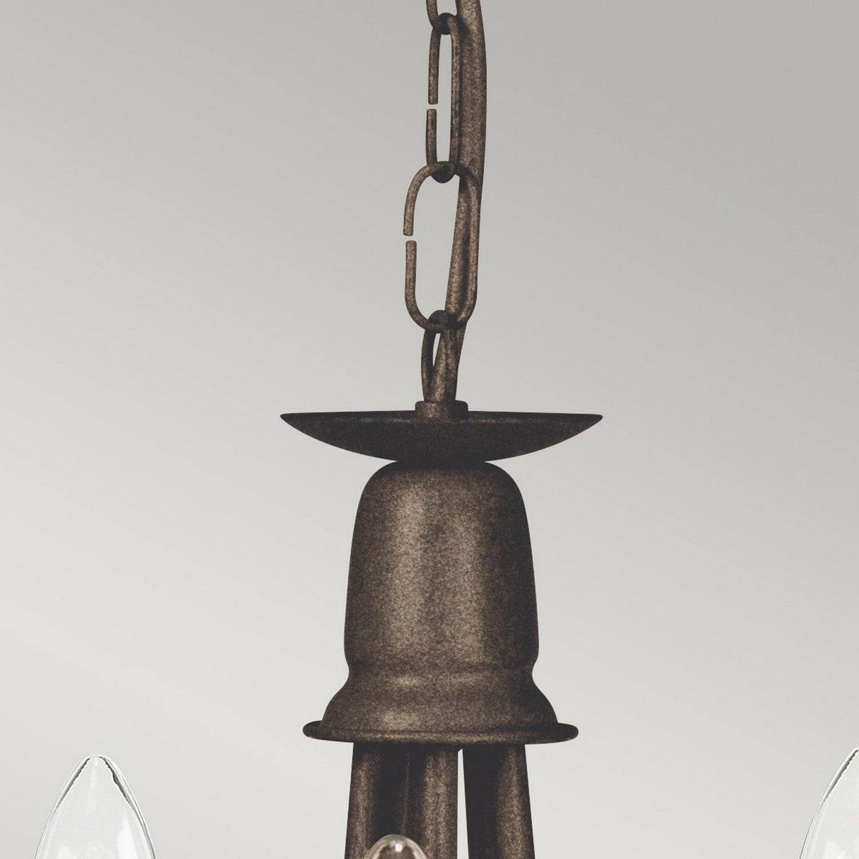 Close-up of the Minster 5 Light Chandelier - Black/Gold Patina, showcasing its rustic finish and chain-link for hanging. The bell-shaped top supports multiple candle-style bulb holders around the edges, making it ideal as a convertible semi-flush fitting against a plain light gray background.