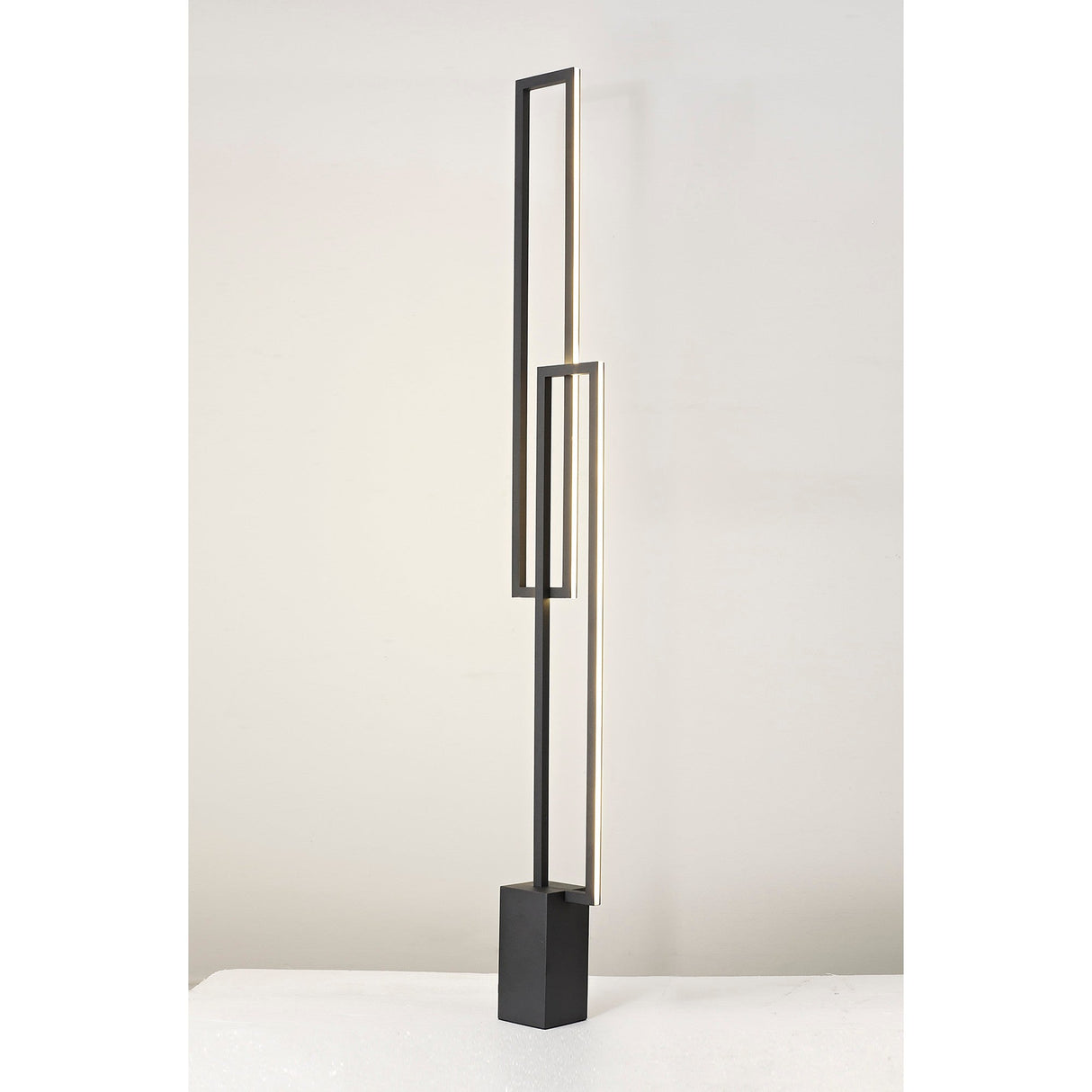 The Mural LED Floor Lamp 48W 3000K in matt black features geometric rectangular frames on a square base, providing dimmable ambient lighting against a plain white background.