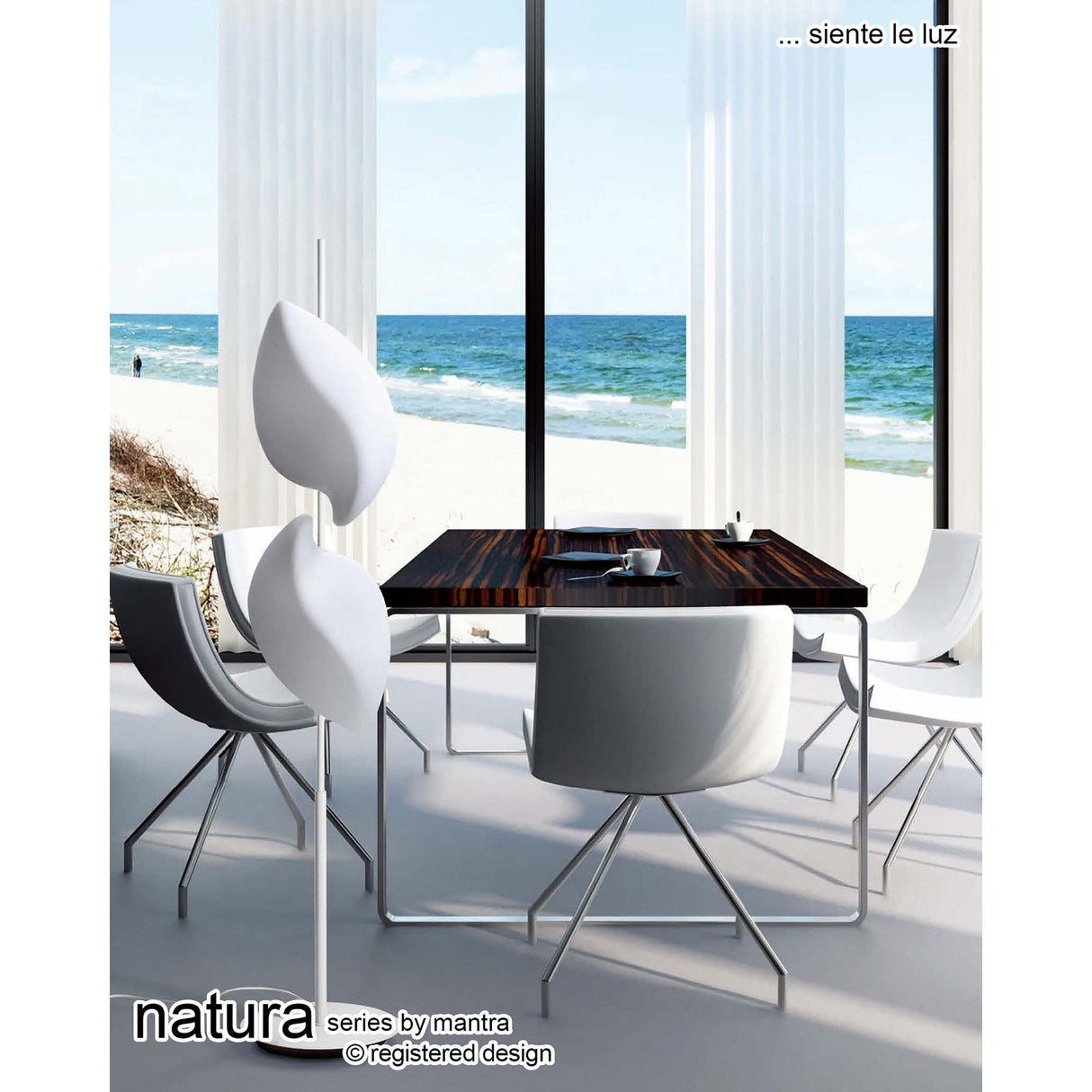 Modern dining area with sleek white chairs, dark wood table, and tall windows overlooking a beach. Vertical blinds filter sunlight. Nature-inspired style enhanced by Natura 4 Light Outdoor Floor Lamp - Matt White/Opal White by mantra.