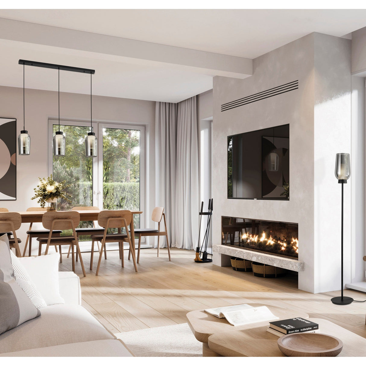 Modern living and dining room with light wood floors, a beige sofa, dining table by large windows, wall-mounted TV above fireplace, pendant lights, neutral decor, and the Nora 1 Light Chrome Glass Floor Lamp with black marble base.