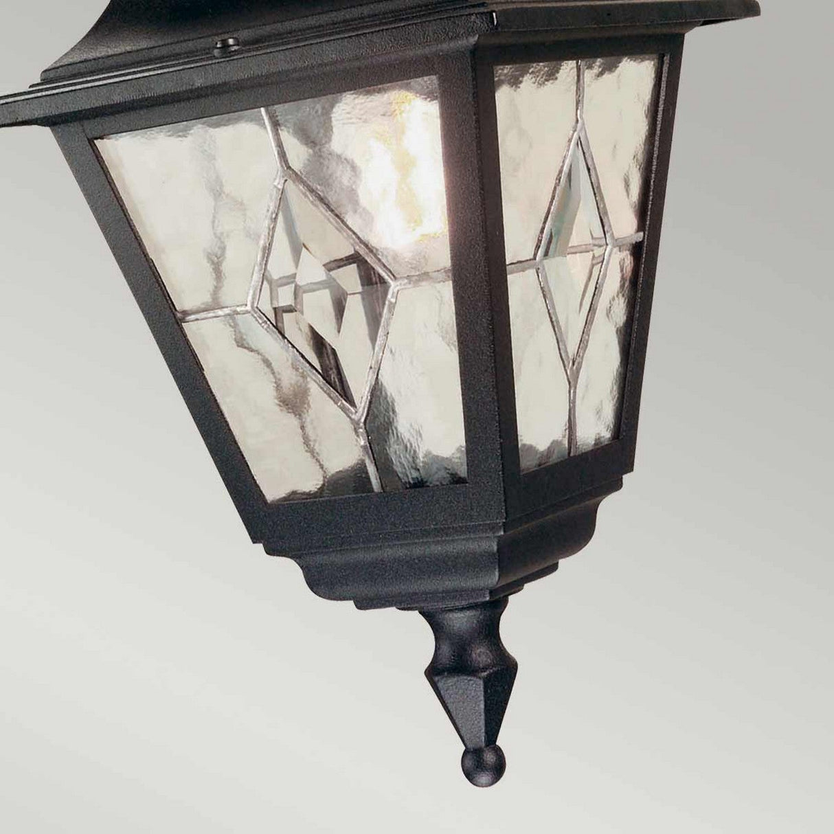 The Norfolk 1 Light Outdoor Chain Pendant in black boasts an outdoor lantern-inspired design with hand-leaded glass panels adorned with diamond patterns. It features a pointed finial at the base and casts a warm glow, making it ideal for outdoor spaces.