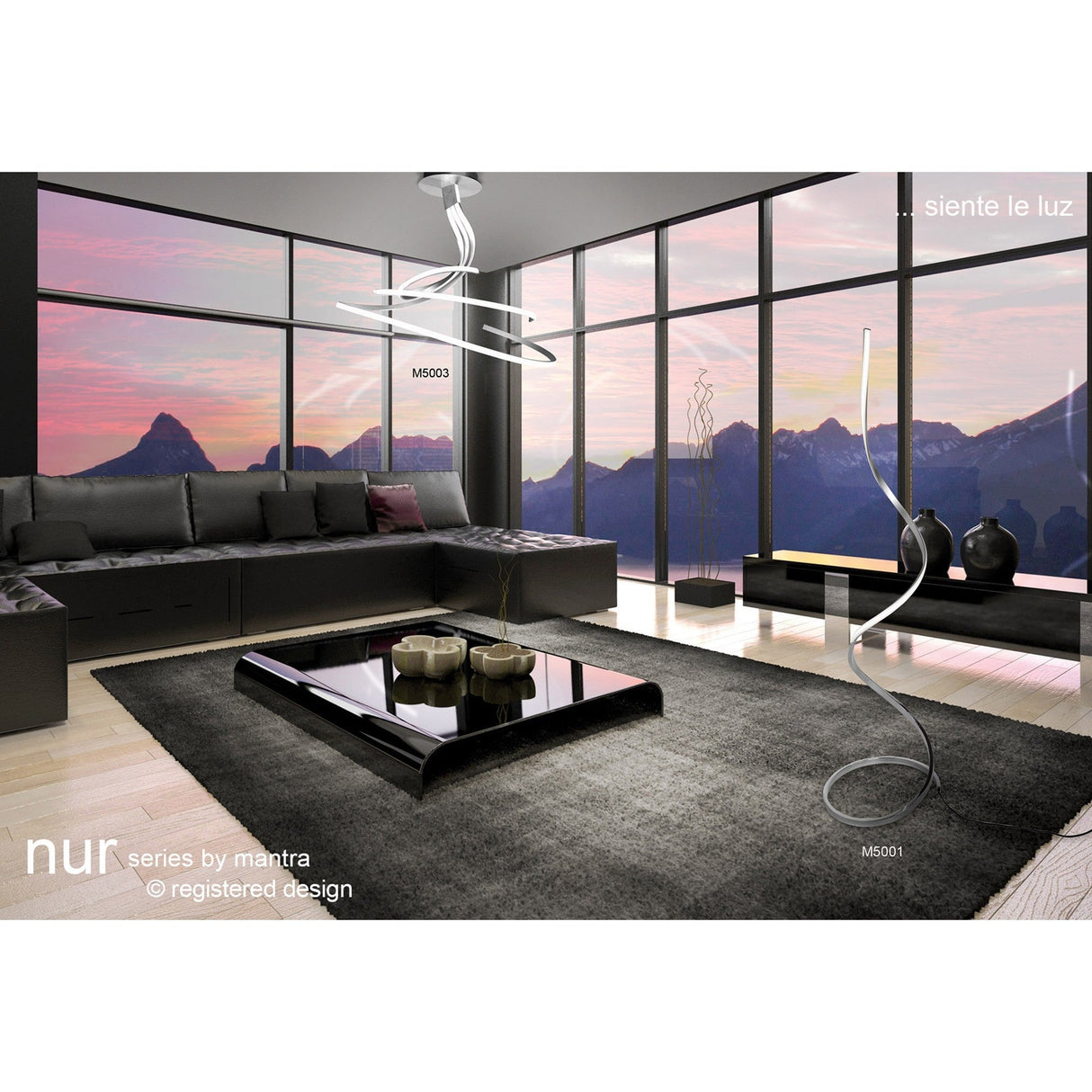 Modern living room featuring a black sofa, low black coffee table, and the Nur Blanco XL Dimmable LED Floor Lamp 20W 3000K - Chrome, set by floor-to-ceiling windows showcasing a mountain sunset. Logo text and product names are visible in the image.