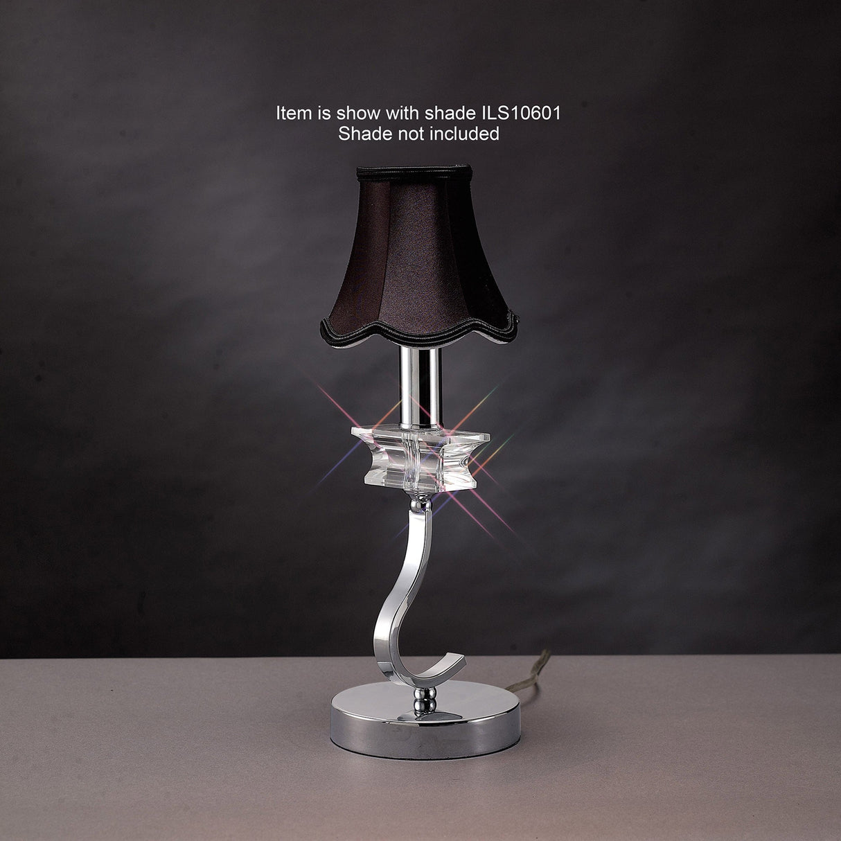 The Nydia 1 Light Crystal Table Lamp features a modern polished chrome curved base with a clear accent. Shown with small black shade ILS10601 (not included).