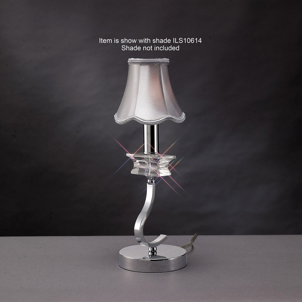 The Nydia 1 Light Crystal Table Lamp features a curvy polished chrome base with a clear accent. Shown with shade ILS10614 (not included).