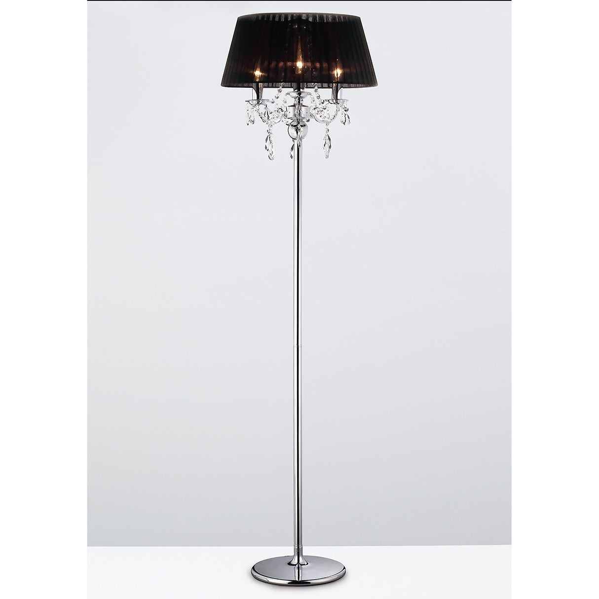 The Olivia 3 Light Crystal Floor Lamp features a shiny chrome stand, black pleated shade, and hanging crystal accents, adding modern elegance to any room. Shown against a plain white background.