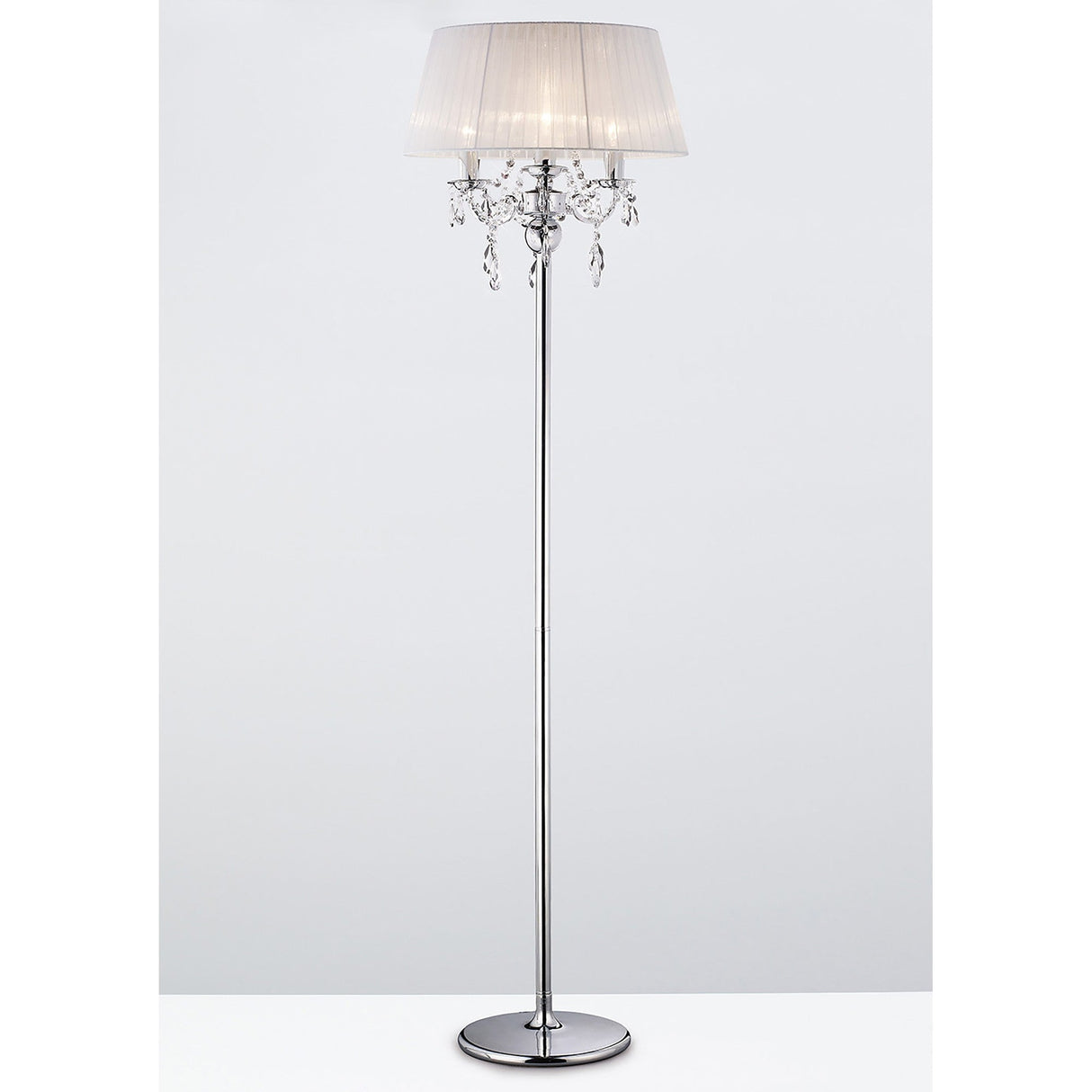 The Olivia 3 Light Crystal Floor Lamp features a slim chrome stand, round base, white pleated shade, and decorative crystal accents beneath the shade, shown against a plain white background.