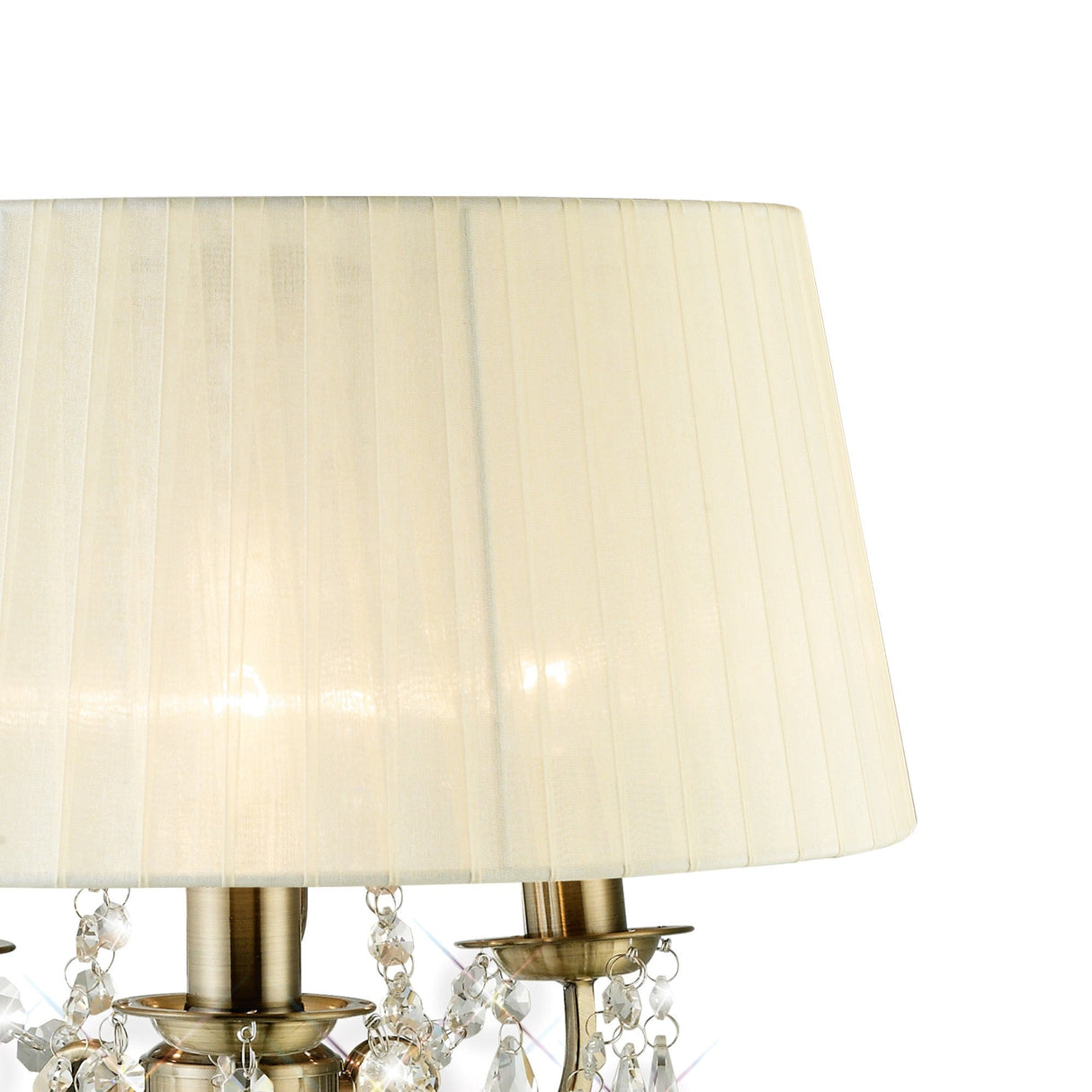 A close-up of the Olivia 3 Light Crystal Table Lamp shows its cream pleated shade, antique brass base, and hanging crystal ornaments, highlighting the lamp’s elegant Flemish-inspired design.