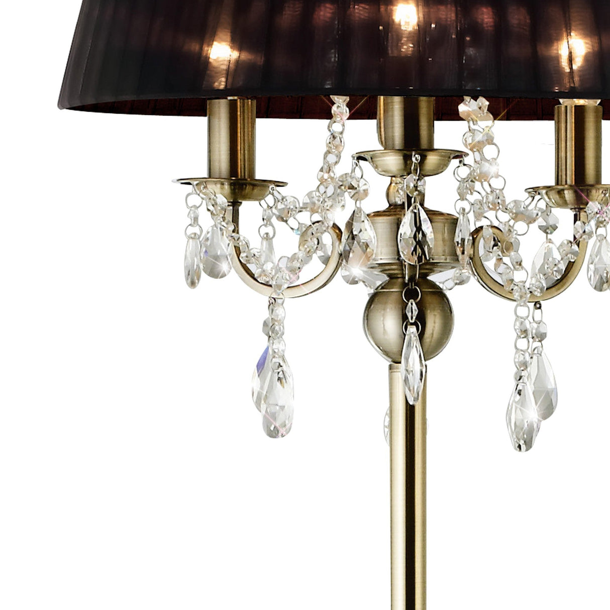 A close-up of the Olivia 3 Light Crystal Floor Lamp in brass, featuring hanging crystal ornaments and a black shade. The crystals catch the light, bringing a touch of luxury to this elegant, timeless design.